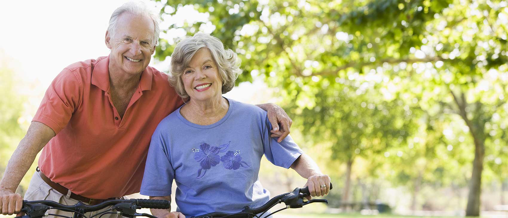 A senior couple smiling with arms around each other